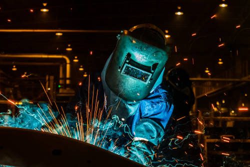 Worker,welding in a car factory with sparks, manufacturing, industry, factory